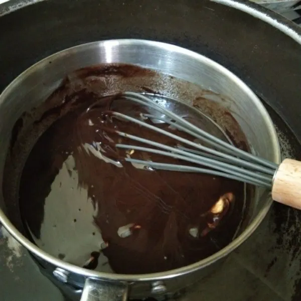 Lelehkan (tim) dark chocolate compund, margarin, dan butter. Jika sudah meleleh dan teraduk rata, angkat.