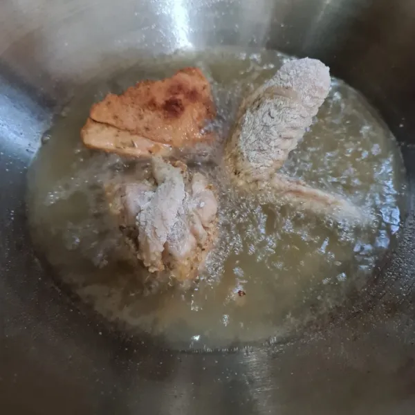 Panaskan minyak goreng lalu goreng ayam hingga matang.