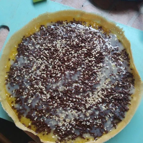 Jika sudah matang, segera keluarkan dari teflon, olesi dengan margarin secukupnya. Tambahkan coklat meses, wijen, susu kental manis. Siap disajikan.