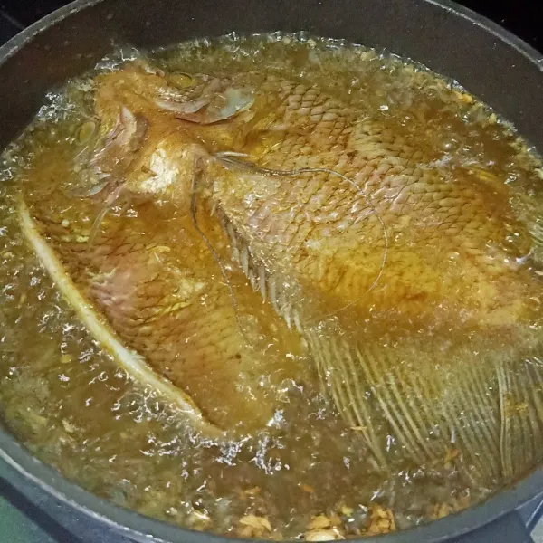 Siapkan wajan lalu masukkan minyak goreng. Setelah minyak panas, ikan yang sudah dimarinasi digoreng sampai matang sampai berwarna kecoklatan keemasan. Balikkan sisi lainnya sampai matang sempurna. Angkat dan sajikan.