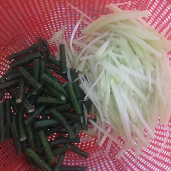 Potong-potong kacang panjang dan iris tipis labu siam.