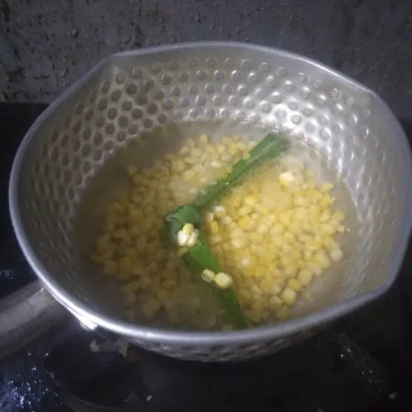 Masukkan jagung dan gula pasir. Aduk hingga air kembali mendidih dan gula larut.