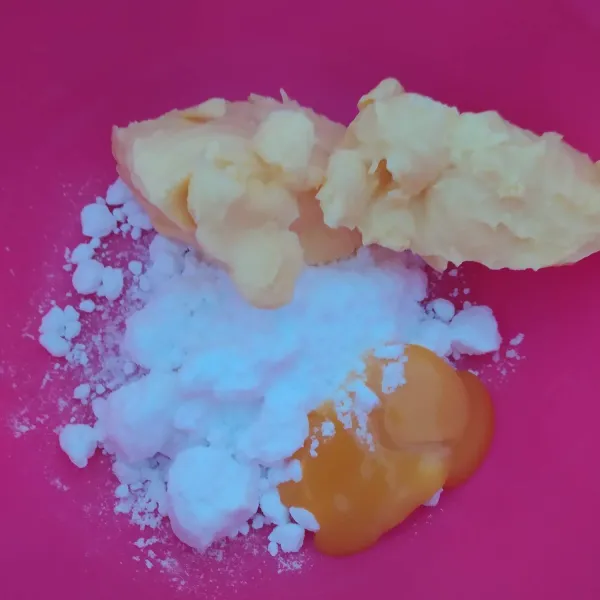 Masukkan kuning telur, margarin dan gula halus kedalam wadah. Kemudian kocok menggunakan mixer/ ballon whisk hingga tercampur rata.