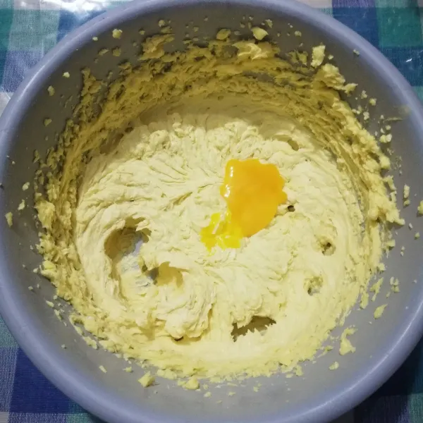 Masukkan kuning telur satu per satu kemudian mixer hingga tercampur rata.
