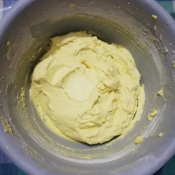 Bagi adonan menjadi 2 bagian, kemudian masukkan setengah bagian tepung terigu. Aduk hingga menjadi adonan yang kalis.