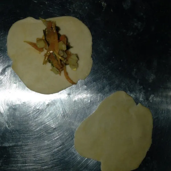 Ambil 2 adonan pipihkan. Beri isian, tutup dengan adonan yang lain. Lalu rapatkan bagian pinggirnya hingga membentuk bulat.