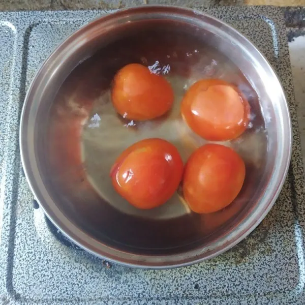 Rebus tomat hingga matang, kupas kulitnya, tiriskan