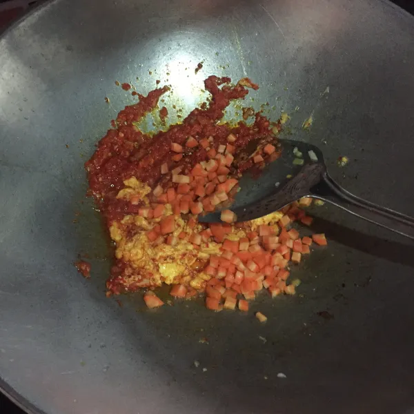 Sisihkan bumbu yang sudah ditumis ke pinggir wajan, masukkan telur lalu aduk-aduk, dan tambahkan wortel. Aduk rata.
