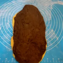 Ambil 1 adonan coklat dan 1 adonan putih, gilas hingga tipis dan lebar. Letakkan adonan coklat di atas adonan putih,lalu gilas lagi.