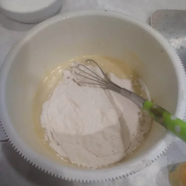 Masukkan tepung terigu dan baking powder. Aduk rata.