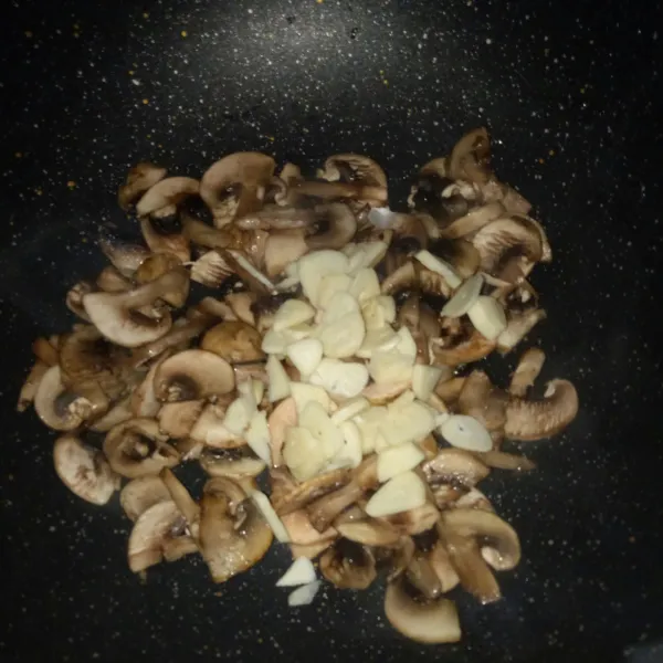 Tumis jamur hingga agak layu, masukkan bawang putih, aduk rata