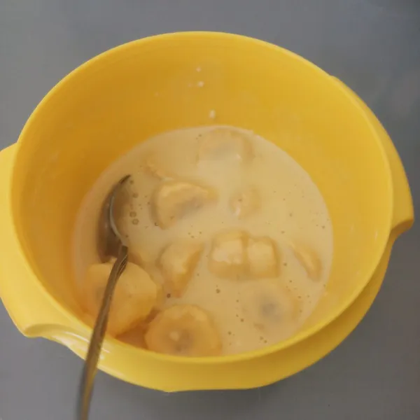 Buat adonan dengan mencampur tepung terigu, gula pasir, telur, dan air (adonan tidak terlalu encer dan tidak terlalu kental). Masukkan pisang yang sudah dikupas dan dipotong kecil-kecil.