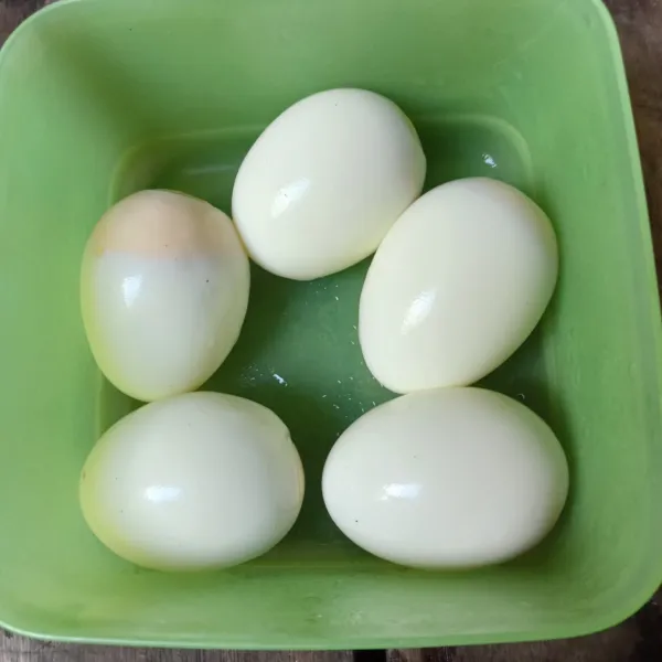 Rebus telur hingga matang dan kupas kulitnya.