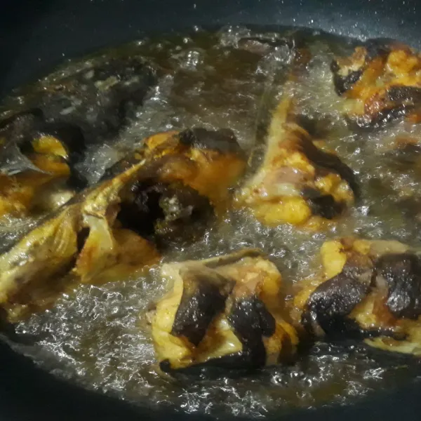 Panaskan minyak goreng lalu goreng ikan lele hingga setengah matang, kemudian angkat dan tiriskan.