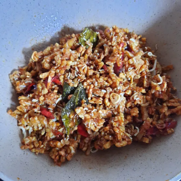 Masukkan tempe goreng, bawang merah goreng, bawang putih goreng, teri goreng dan cabai merah keriting goreng. Aduk cepat supaya lengket satu sama lain. Tunggu dingin dan mengeras lalu simpan dalam wadah kedap udara.