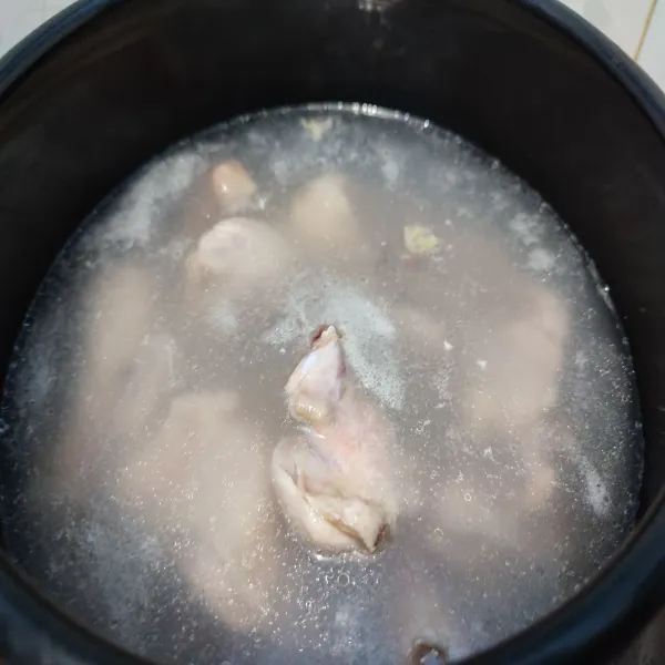 Didihkan 1 liter air, kalau sudah mendidih masukkan ayam. Rebus sebentar hingga keluar busa. Buang air rebusan pertama. Cuci bersih kembali ayam. Lalu rebus kembali ayam dengan sisa air.