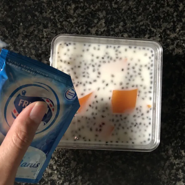 Potong-potong kotak yang di dalam cetakan lalu beri susu dan skm putih ke dalam piring saji
