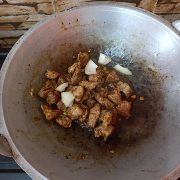 Setelah daging dan bawang tercampur rata, masukkan saus lada hitam dan saus tiram. Aduk hingga saus meresap.