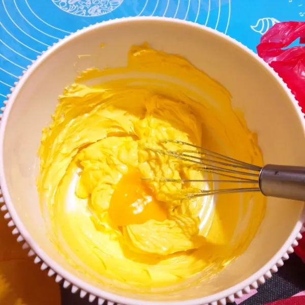 Aduk margarine dan gula halus hingga creamy lalu tambahkan kuning telur, aduk kembali