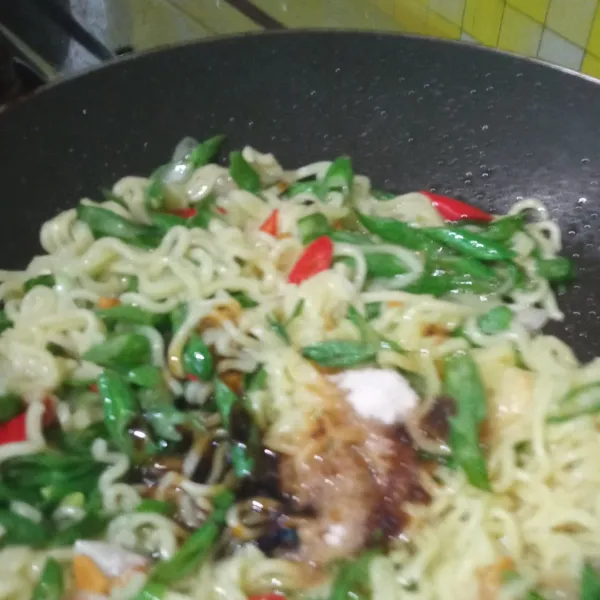 Masukkan semua bumbu indomie, tambah sedikit garam, aduk rata. Matikan api, pindahkan mie ke atas piring saji. Sajikan.