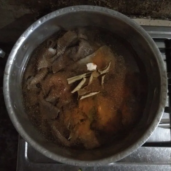 Tambahkan daun jeruk kering dan juga sereh yang telah di keprak. Rebus hingga empuk.