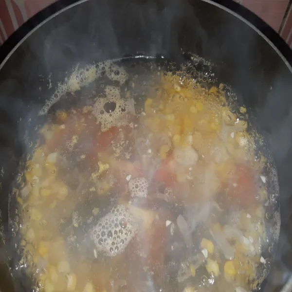 Masukkan bawang merah dan bawang putih.Kemudian tambahkan jagung. Setelah jagung mulai matang, masukkan tomat.