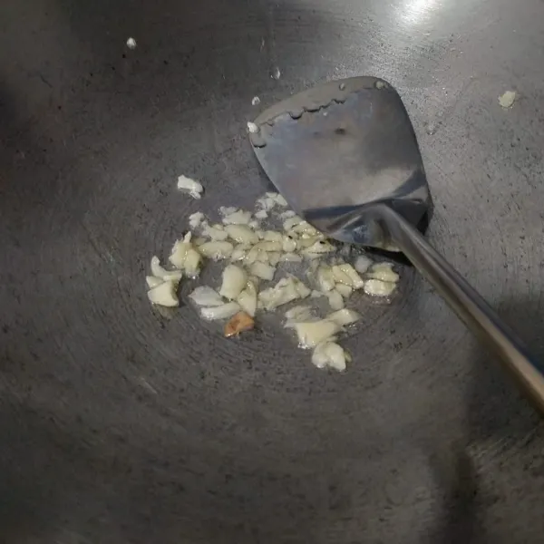 Tumis bawang putih hingga layu dan harum.