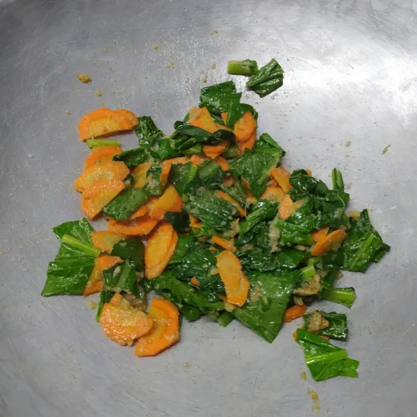 Masukkan irisan wortel sampai ½ matang. Masukkan sawi hijau tumis sampai layu.