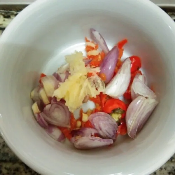 Siapkan wadah, iris bawang merah dan cabe rawit, haluskan bawang putih