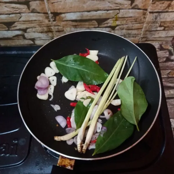 Tumis bumbu iris, daun jeruk, daun bawang serta sereh hingga harum.