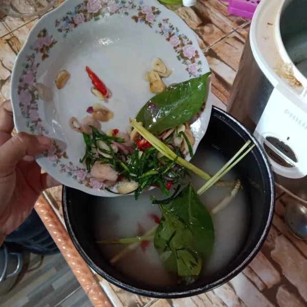 Masukkan bumbu iris ke dalam beras yang sudah dicuci dan diberi air.
