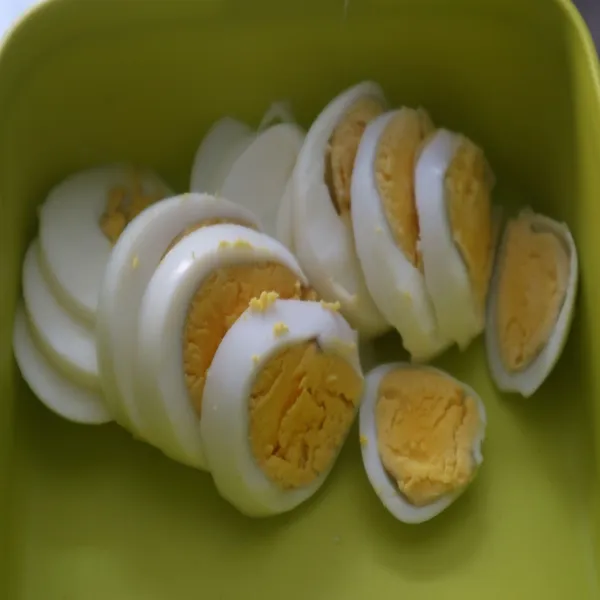 Rebus telur hingga matang, kupas kulitnya, lalu iris iris sesuai selera dan sisihkan di wadah bersih.