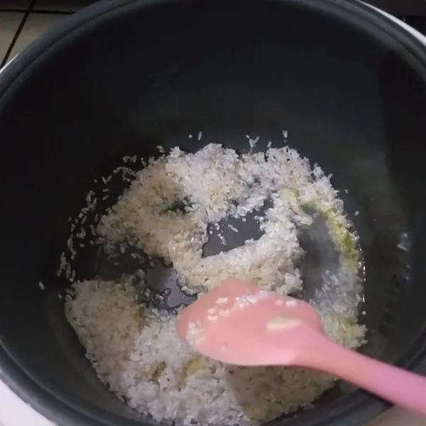 Masukan beras yang sudah ditiriskan, tumis sebentar. Kemudian masukan air, garam, dan kaldu. Masak hingga setengah matang.