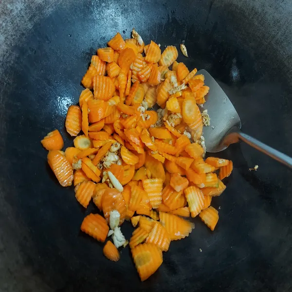 Tumis bawang putih hingga harum, masukkan wortel.