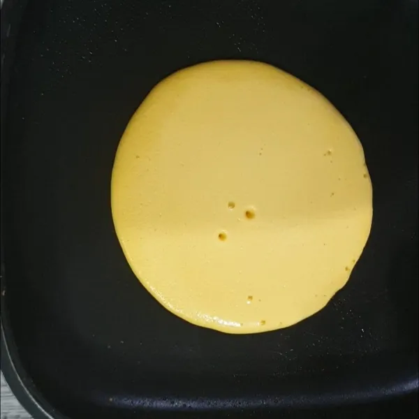 2. Panaskan teflon dengan api kecil lalu diolesi butter atau mentega.
3. Setelah teflon cukup panas, tuang adonan pancake sebanyak 2 sendok sup ke dalam teflon hingga membentuk lingkaran .