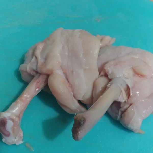 Bentangkan ayam, potong di persendiannya lalu dorong kulit ayam ke atas hingga membentuk pentungan kecil.