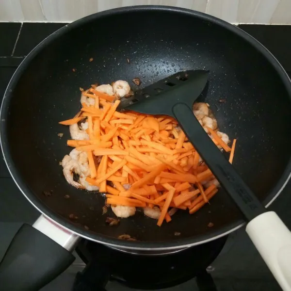 Lalu masukkan wortel, aduk rata. Masak hingga wortel setengah layu.