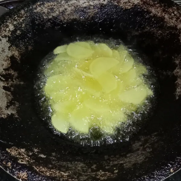 Kupas kentang dan potong-potong tipis, lalu goreng hingga kering.