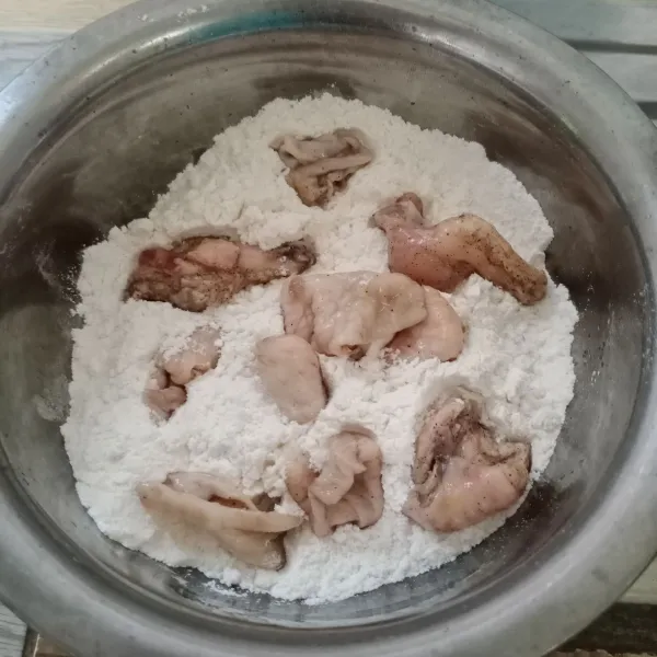 Masukkan kulit ayam ke dalam campuran terigu. Balut merata sambil dicubit-cubit.