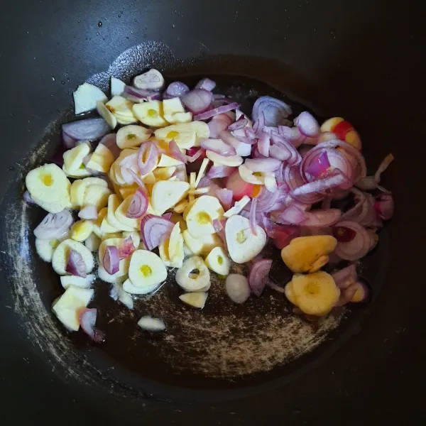 Panaskan minyak. Tumis irisan bawang merah dan bawang putih hingga harum.