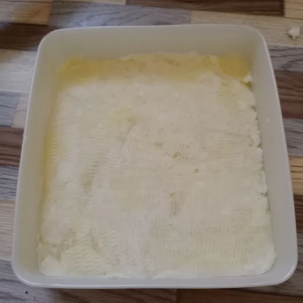 Tuang bahan getuk ke dalam wadah lalu padatkan menggunakan sendok.