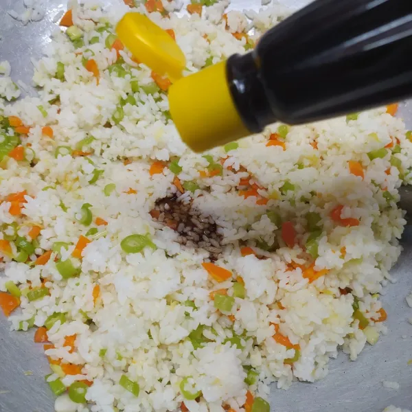 Masukkan nasi, daun bawang, bumbui merica bubuk, saos tiram, kecap asin dan kaldu jamur. Aduk sampai rata sambil koreksi rasa sesuai selera