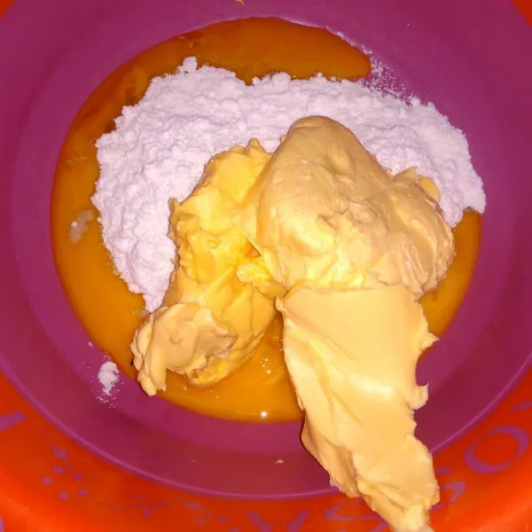 Campur kuning telur, margarin, mentega dan gula halus, kocok sebentar asal tercampur rata saja.