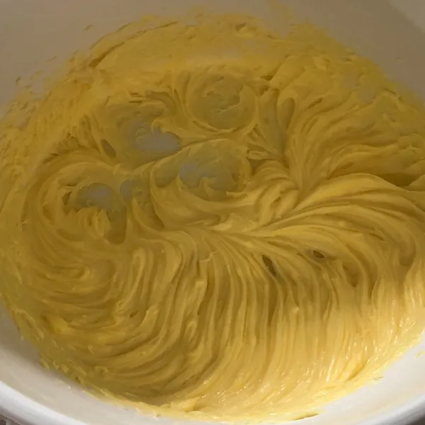 Dalam wadah campur mentega, vanilla extract dan gula halus kocok sampai creamy saja, pakai whisk atau mixer kecepatan paling rendah sebentar saja. Lalu masukkan kuning telur. Aduk kembali dengan whisk.