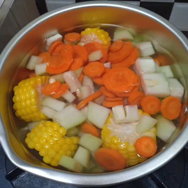 Masukkan potongan labu dan wortel, masak hingga setengah matang.