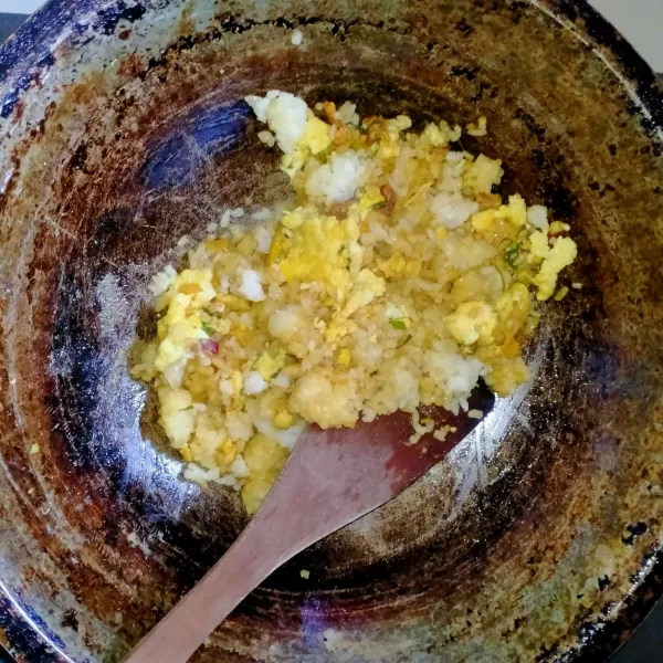 masukkan nasi dan tambahkan bumbu penyedap. Aduk rata. Gunakan api kecil. Koreksi rasa. Angkat dan sajikan.