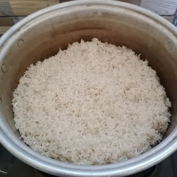 Cuci bersih beras. Didihkan air dalam panci pengukus. Kemudian masukkan beras ke dalam panci.