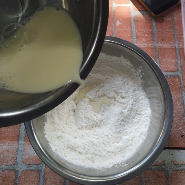 Aduk rata telur dan susu cair, campurkan ke dalam adonan kering, uleni sampai rata.