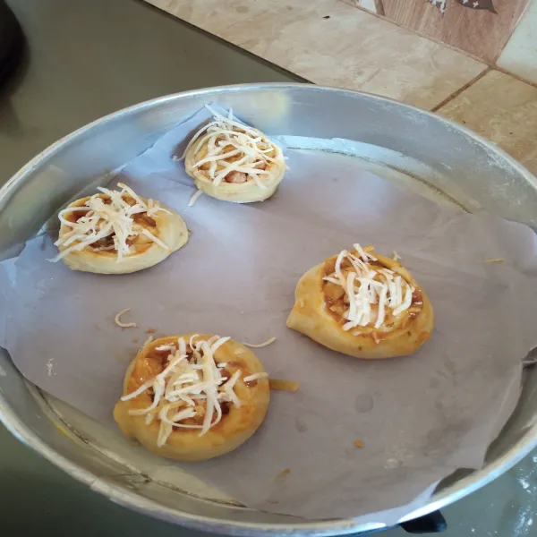 Gulung, kemudian potong-potong. Taburi dengan keju, diamkan sebentar sampai mengembang. Oven suhu 170° api atas bawah selama 15 menit