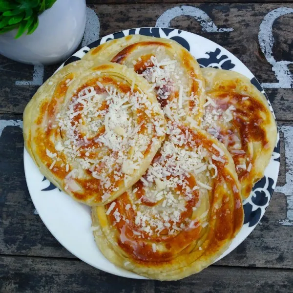 Taburi dengan keju parut dan susu kental manis, sajikan.